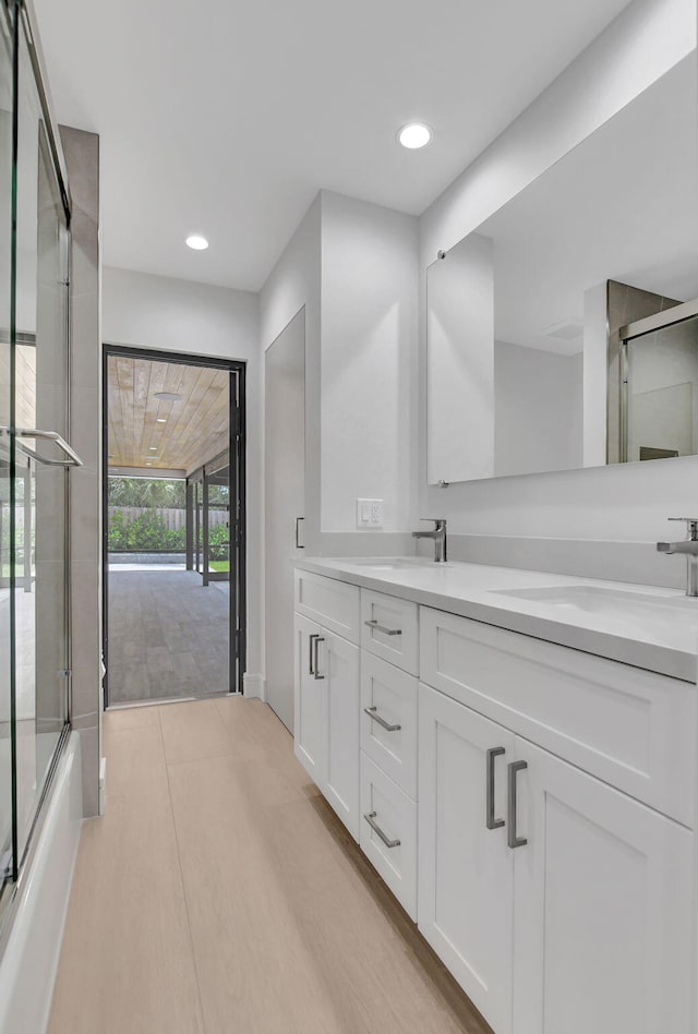 bathroom with vanity and bath / shower combo with glass door