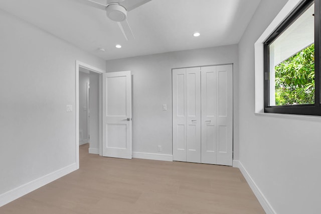 unfurnished bedroom with light wood-type flooring, a closet, and ceiling fan