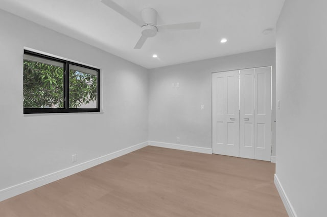 unfurnished bedroom with ceiling fan, light wood-type flooring, and a closet