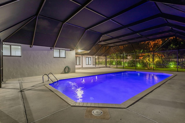 view of swimming pool with glass enclosure and a patio area