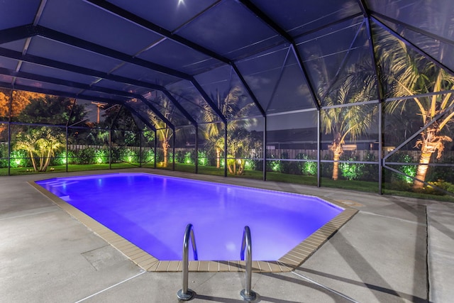 view of swimming pool with glass enclosure and a patio