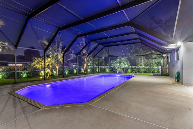 view of swimming pool featuring glass enclosure and a patio area