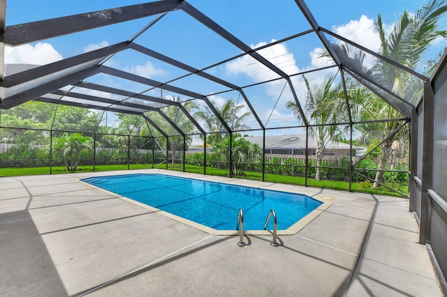 view of pool with glass enclosure and a patio area