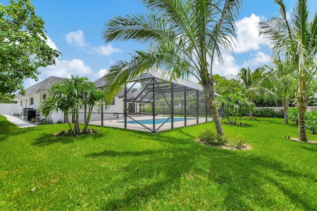 view of swimming pool featuring a lawn and a lanai