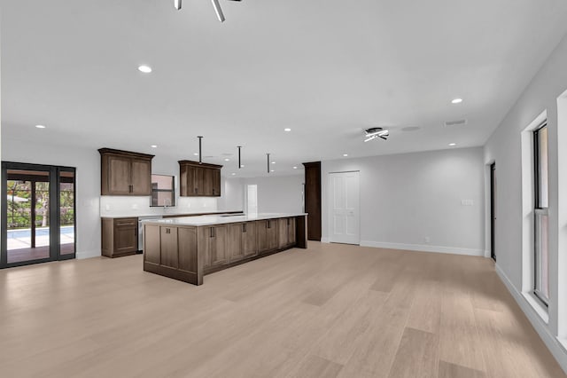 kitchen with light hardwood / wood-style flooring, decorative light fixtures, and a center island