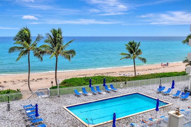 view of pool with a water view and a beach view