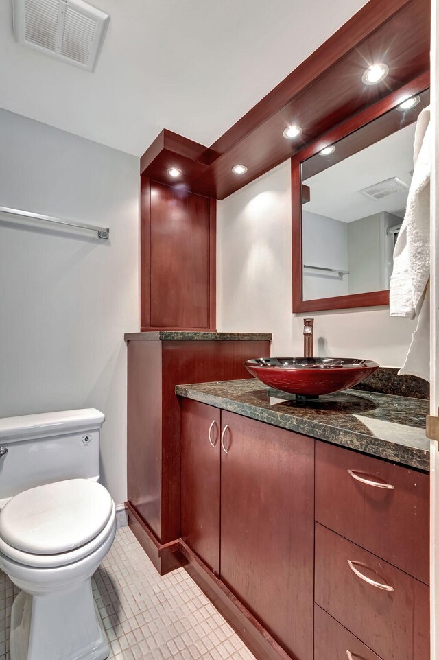 bathroom with vanity, toilet, and tile patterned flooring