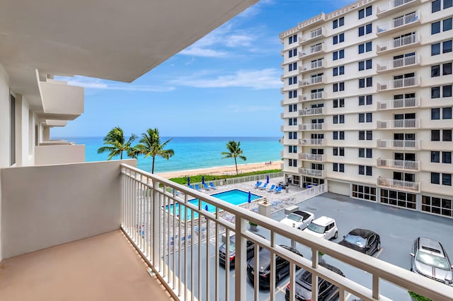 balcony with a water view and a community pool