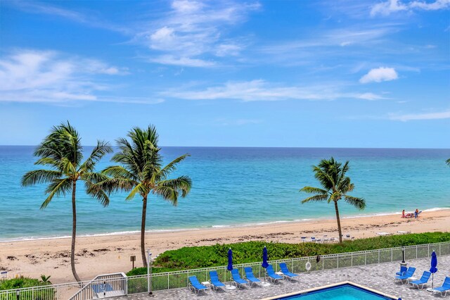 view of pool with a water view and a view of the beach