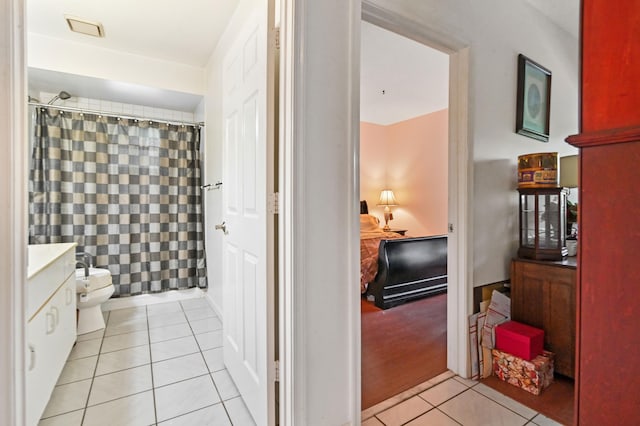 bathroom with toilet, a shower with curtain, vanity, and tile patterned flooring