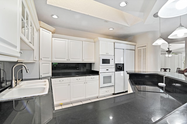 kitchen featuring sink, hanging light fixtures, ceiling fan, white cabinets, and built in appliances