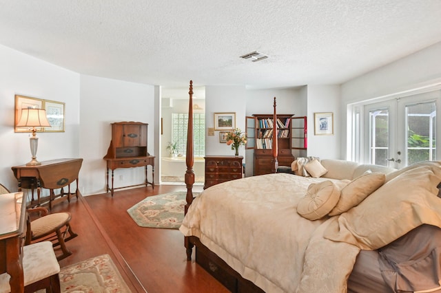 bedroom featuring french doors, a textured ceiling, access to exterior, and dark hardwood / wood-style flooring