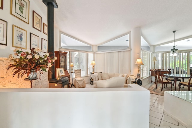 tiled living room with lofted ceiling, a healthy amount of sunlight, and ceiling fan