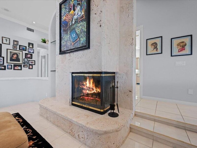 interior details featuring a high end fireplace, crown molding, and tile patterned floors