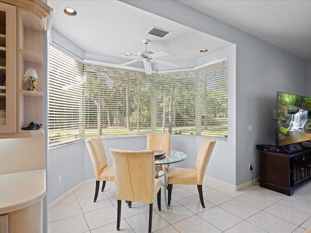 dining space with ceiling fan and light tile patterned floors