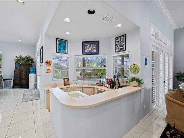 living room with sink, crown molding, and light tile patterned flooring