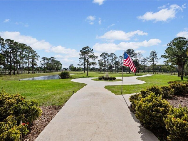 view of community with a lawn and a water view