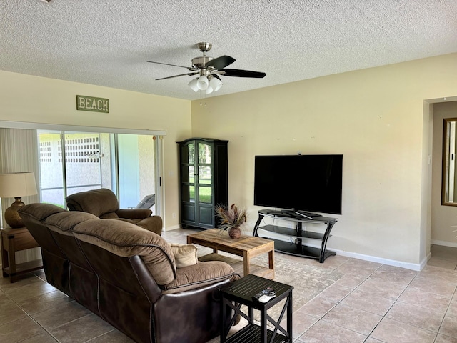 living room featuring ceiling fan, light tile patterned floors, and a textured ceiling