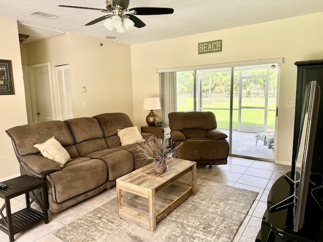 tiled living room featuring a textured ceiling and ceiling fan