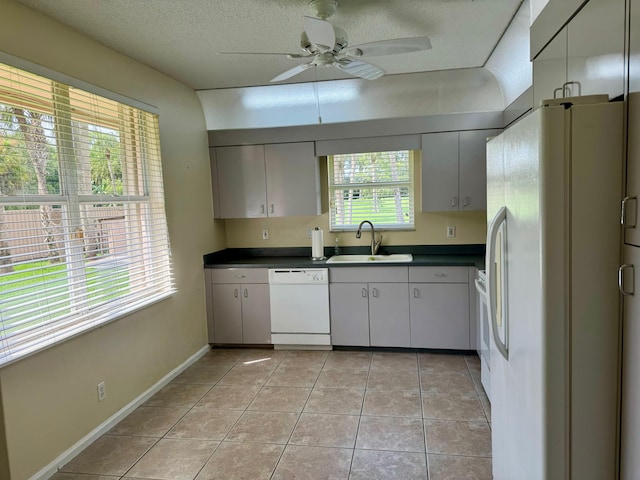 kitchen featuring a healthy amount of sunlight, white appliances, sink, and ceiling fan