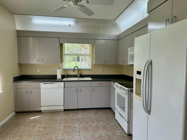 kitchen with a textured ceiling, gray cabinetry, white appliances, sink, and ceiling fan