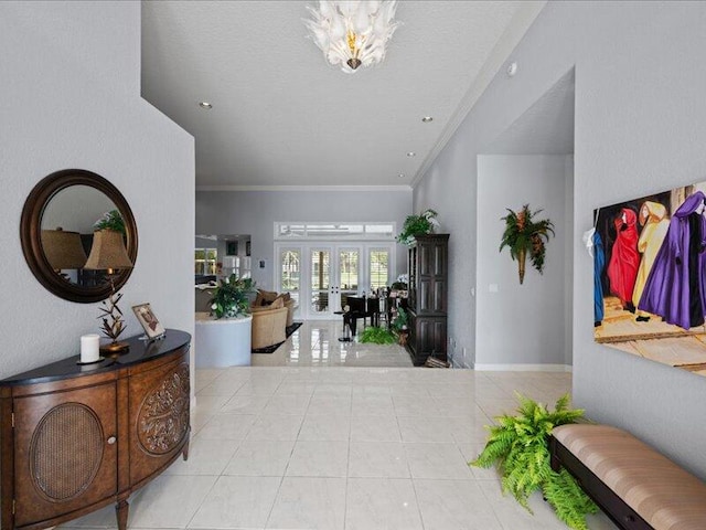 entryway featuring light tile patterned flooring, crown molding, and french doors