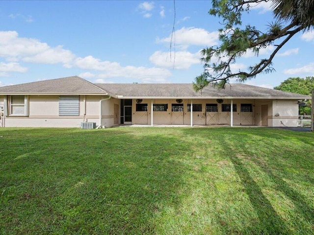 rear view of property with cooling unit and a lawn