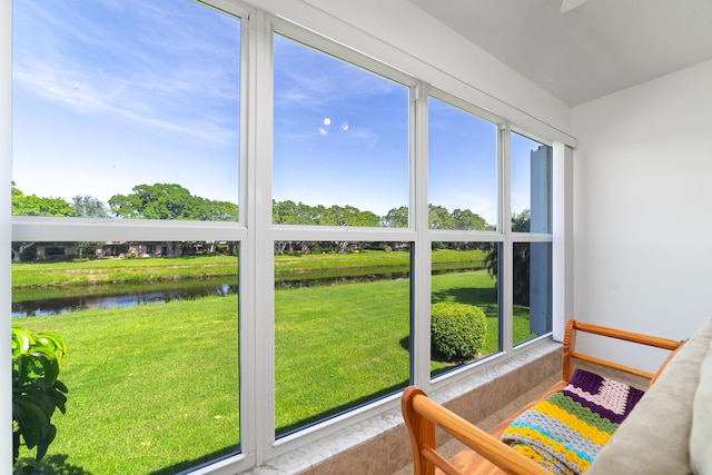 sunroom with a wealth of natural light and a water view