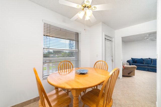 dining space featuring ceiling fan and light tile patterned floors