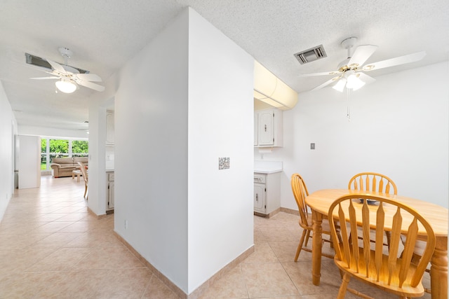 dining space with ceiling fan, light tile patterned floors, expansive windows, and a textured ceiling