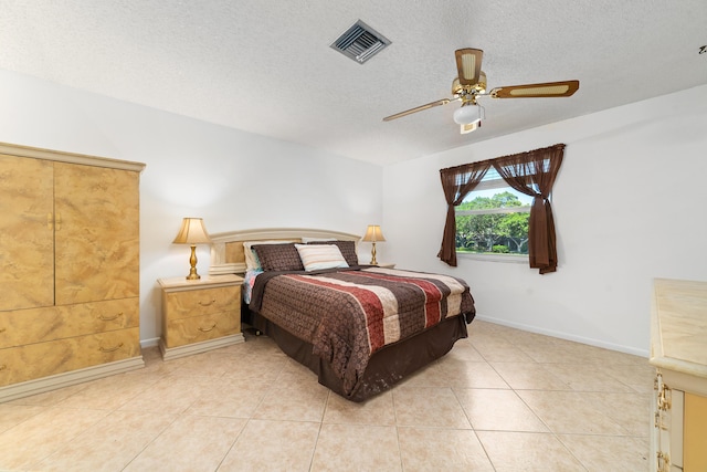 bedroom featuring a textured ceiling, ceiling fan, and light tile patterned flooring