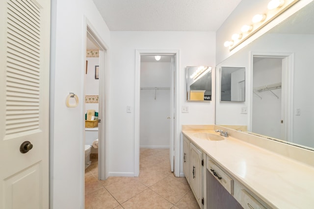 bathroom featuring toilet, vanity, tile patterned flooring, and a textured ceiling