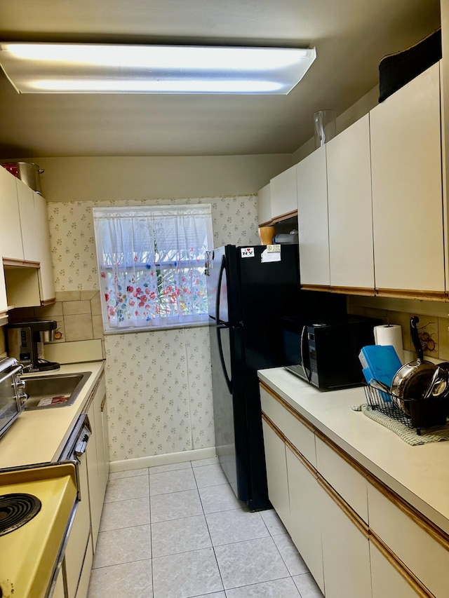 767 E High Point Dr E Unit C, Delray Beach, FL 33445 - kitchen with black microwave, wallpapered walls, light countertops, light tile patterned flooring, and white cabinetry