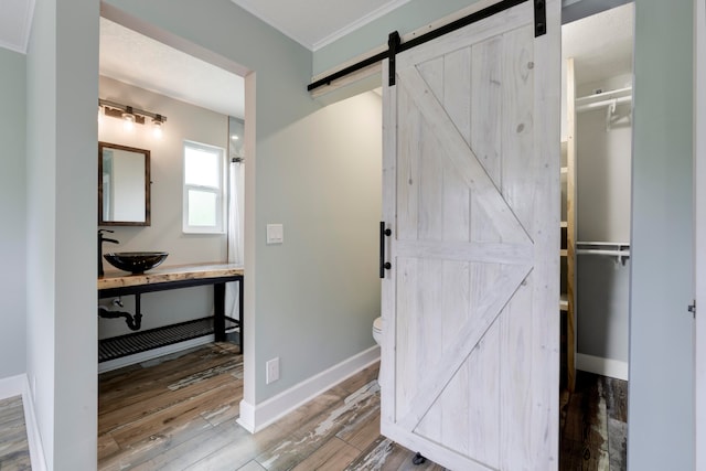 bathroom featuring hardwood / wood-style flooring, crown molding, toilet, and vanity