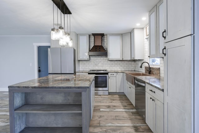 kitchen with a center island, stainless steel appliances, light hardwood / wood-style floors, light stone countertops, and wall chimney exhaust hood