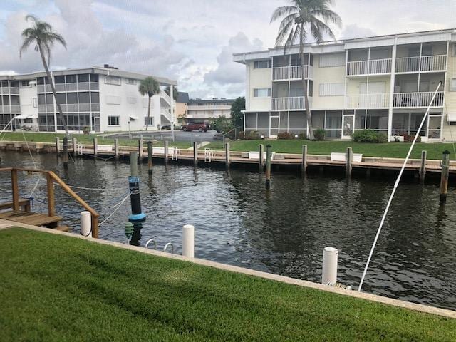 view of dock featuring a water view and a yard