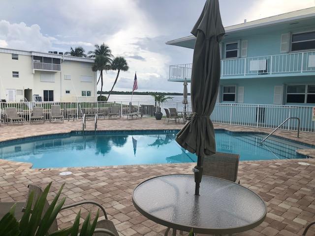 community pool with a patio area and fence