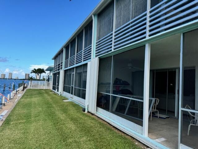 view of yard with a sunroom and a water view