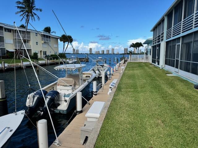 dock area featuring a water view and a lawn