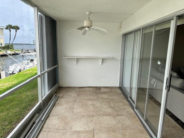 unfurnished sunroom with a water view and ceiling fan