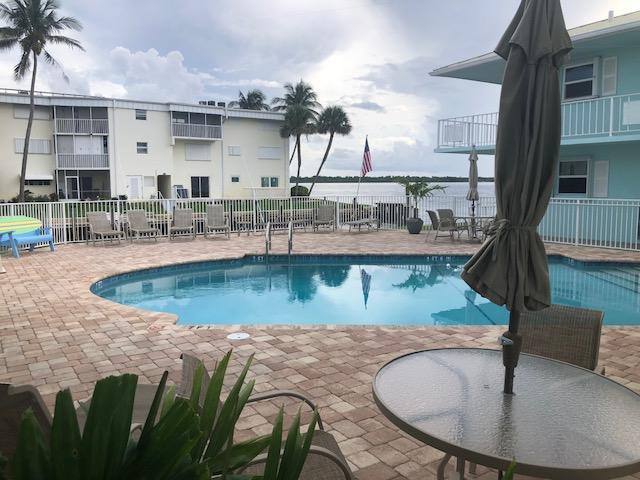 community pool with fence and a patio