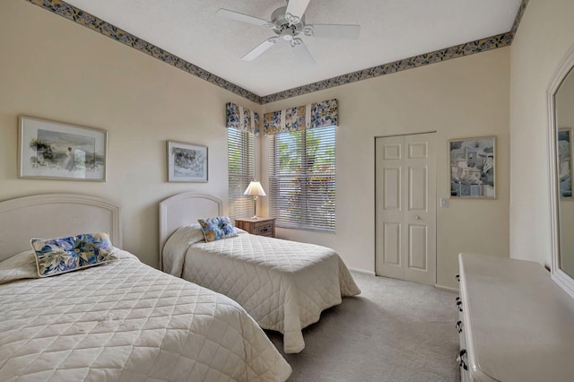 carpeted bedroom with ceiling fan, a closet, and a textured ceiling