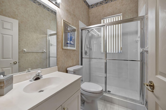 bathroom featuring tile patterned flooring, vanity, toilet, and an enclosed shower