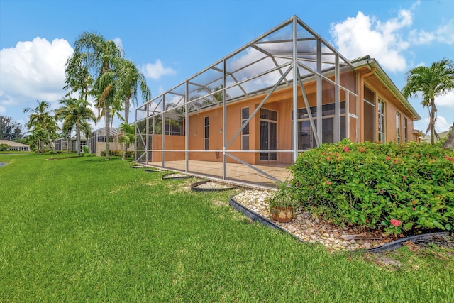 rear view of property with a lanai and a lawn