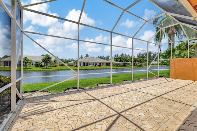 view of patio featuring a lanai and a water view