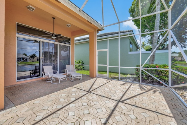 view of patio / terrace with ceiling fan and glass enclosure