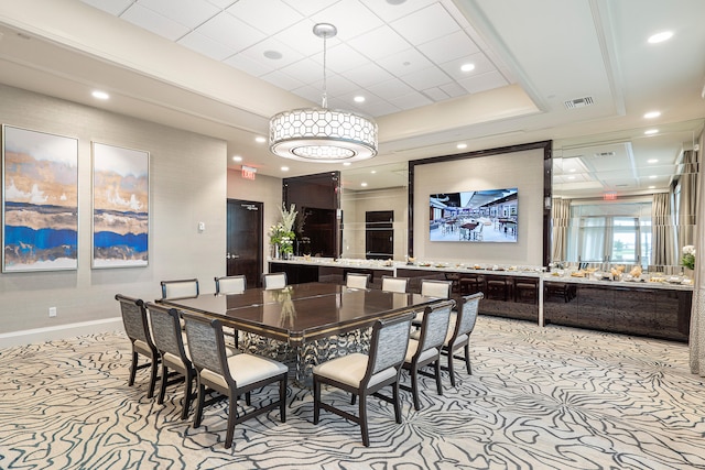 dining space with a tray ceiling and light colored carpet