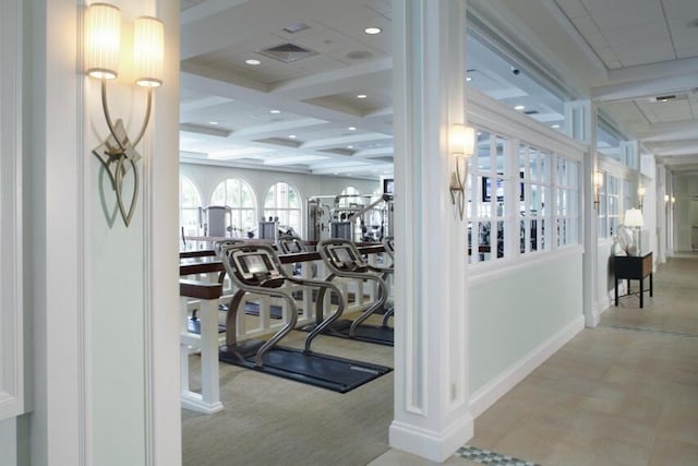 workout area featuring coffered ceiling