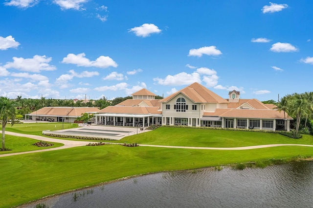 back of property with a yard and a water view