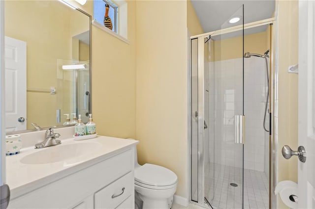 bathroom featuring toilet, a shower with shower door, and vanity